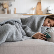 Sad Teen Girl Wrapped in Blanket Looking At Phone