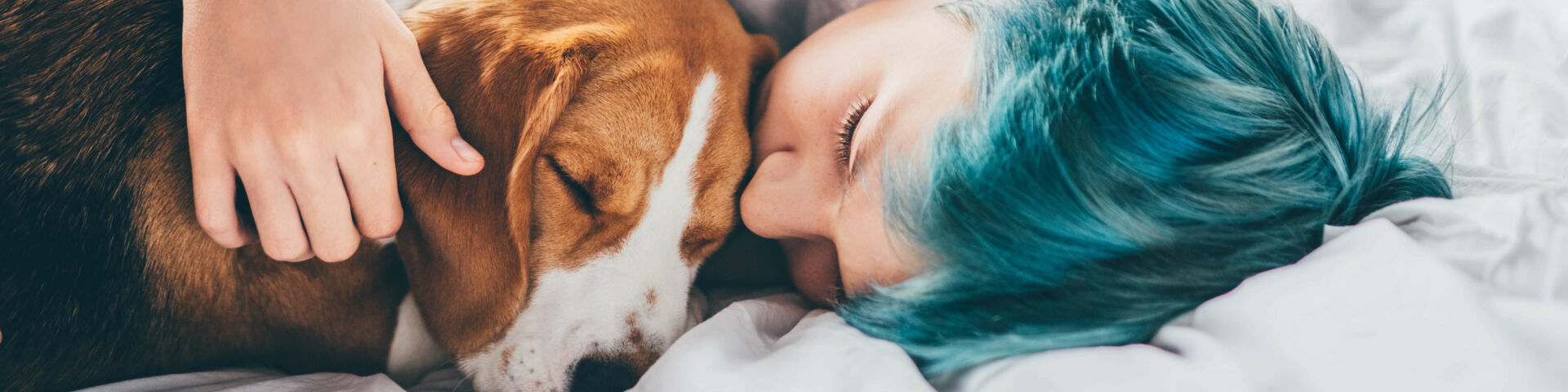 Niño acostado en la cama acurrucando al perro