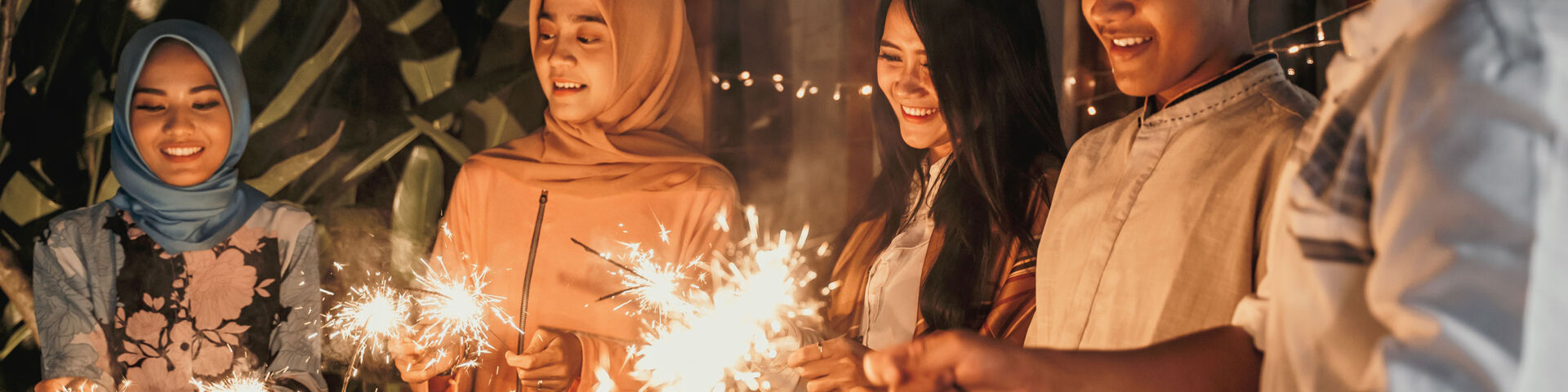 Family holding sparklers in celebration of Eid al-Fitr.