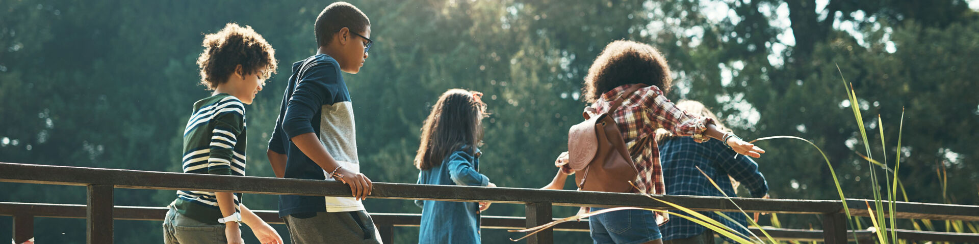 Group of teens walk across footbridge AdobeStock_482456711