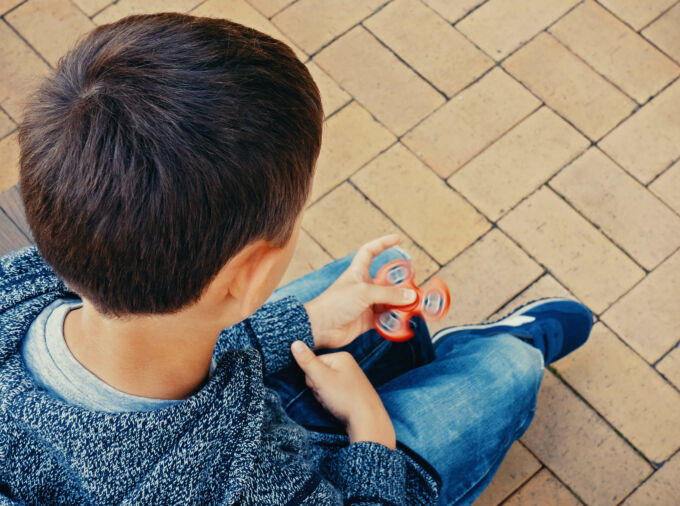 Un chico usando un fidget spinner