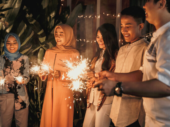 Familia sosteniendo bengalas en celebración de Eid al-Fitr.