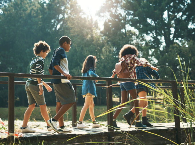 Un grupo de adolescentes camina a través de un puente peatonal AdobeStock_482456711