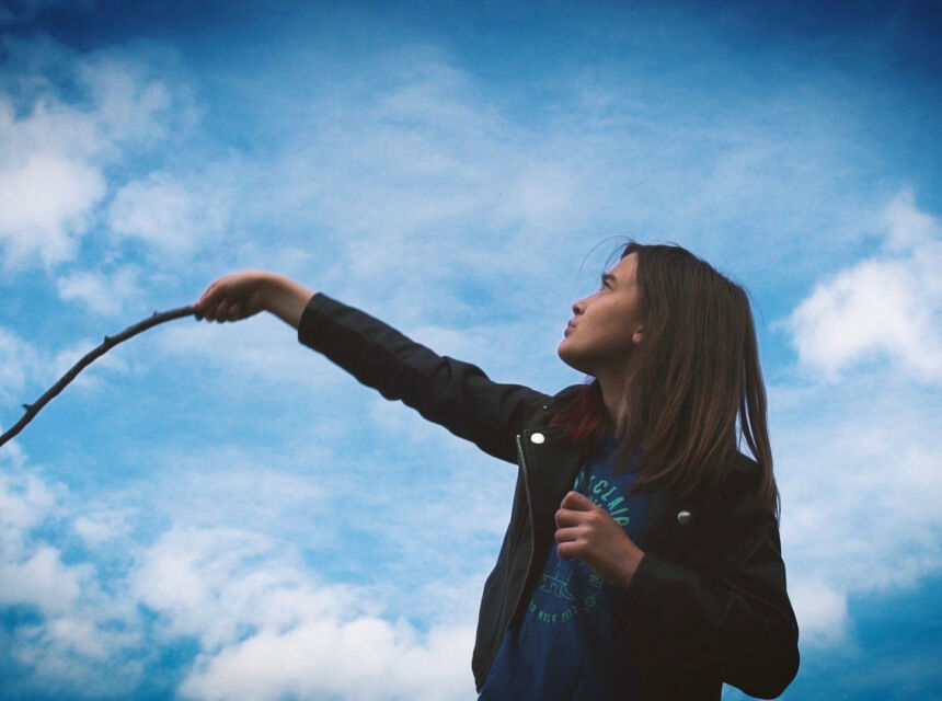 girl swings stick towards sky